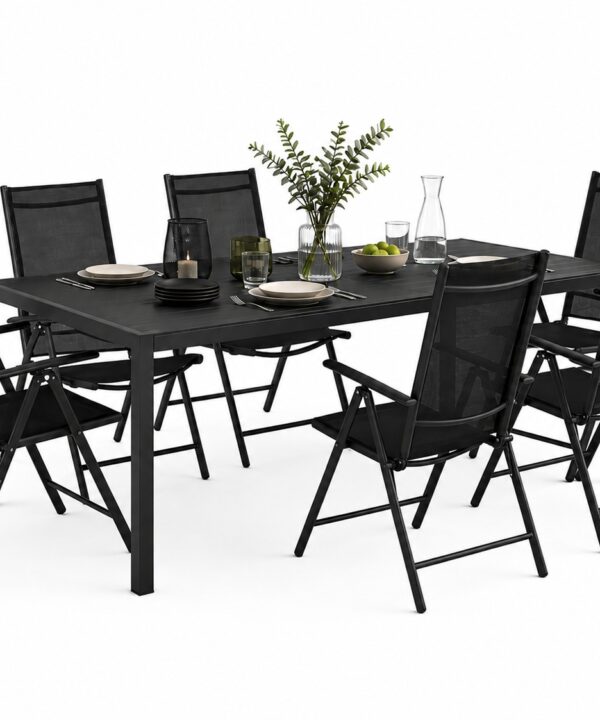 Outdoor black dining table with eight matching folding chairs set for a meal, with plates, glasses, and a centerpiece plant arrangement.